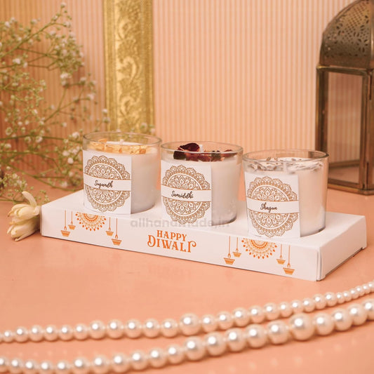 Three scented candles in glass jars with decorative labels.