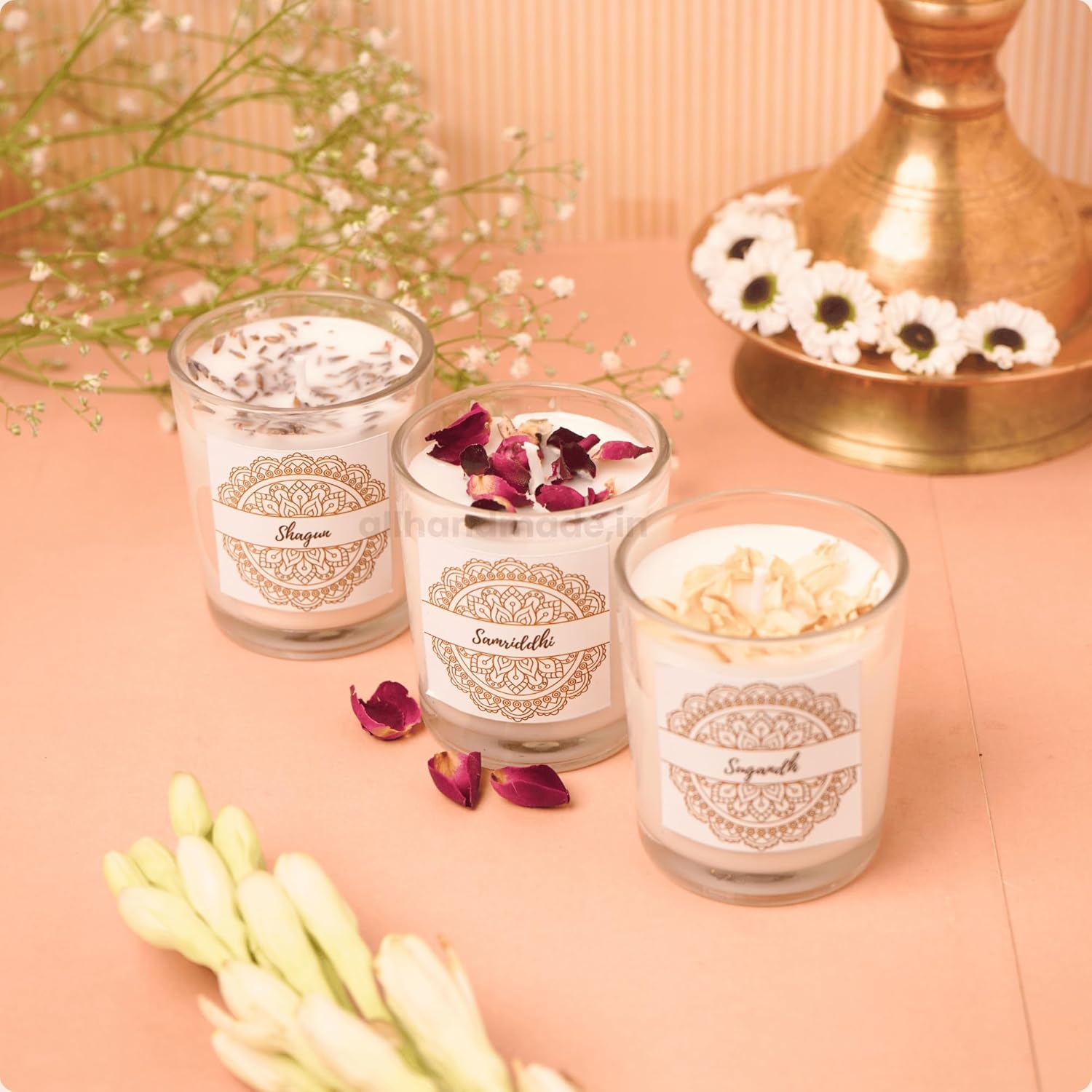 Three glass candles with decorative labels 