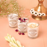 Three glass candles with decorative labels 